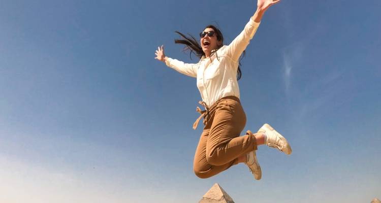 Een persoon die springt voor de piramides in Egypte.
