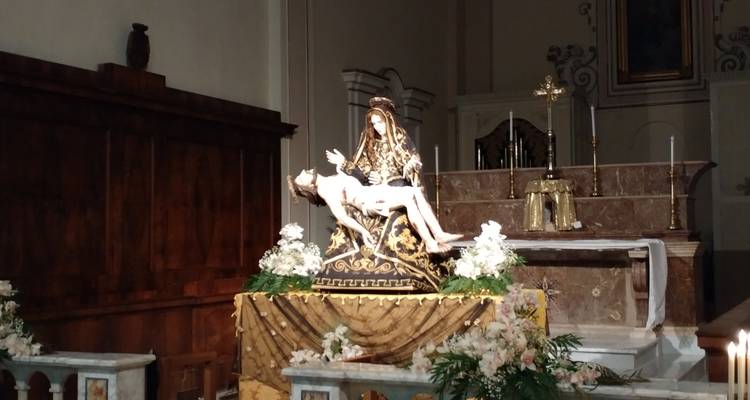 Estatua religiosa y altar dentro de una iglesia.
