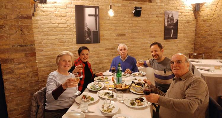 Personas cenando en una mesa de restaurante con platos y bebidas.