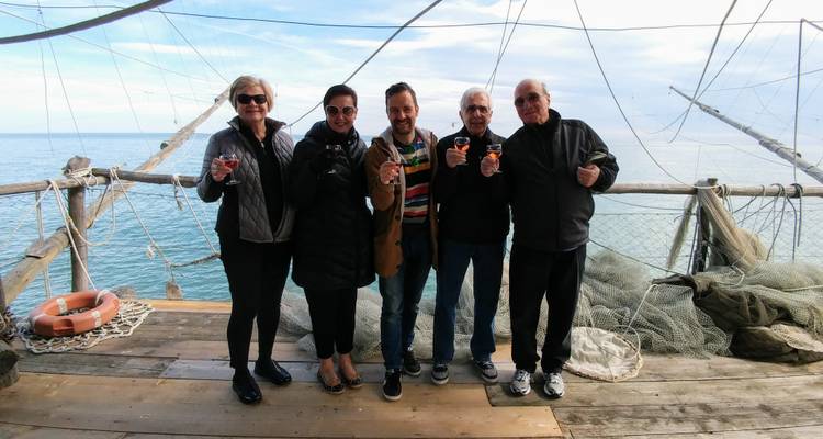 Grupo de personas paradas en una plataforma de madera sobre el agua.