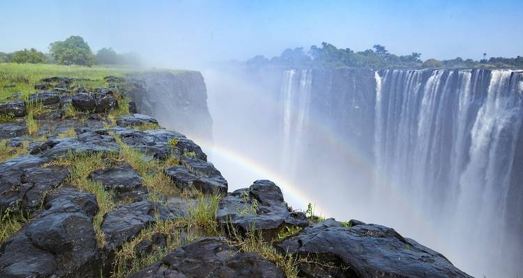 Vue emblématique d'une cascade avec un arc-en-ciel.