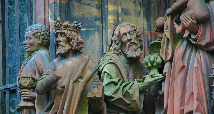 Detalladas estatuas de piedra de los Tres Reyes adornando la fachada de una catedral gótica