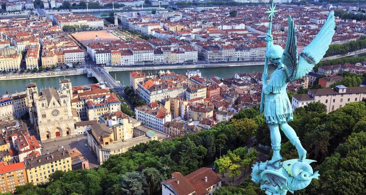 Vista aérea de una ciudad con una gran estatua metálica en primer plano.
