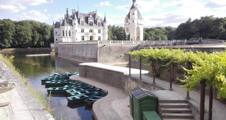 Château de Chenonceau avec vue sur la rivière et bateaux.