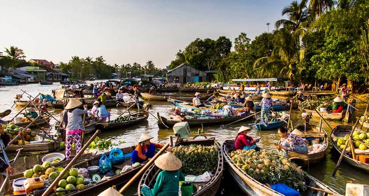 Busy floating market with boats filled with goods.