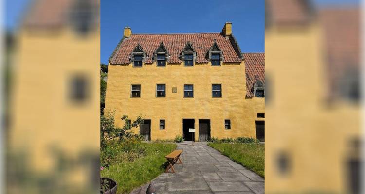 Bright yellow building with a traditional roof.