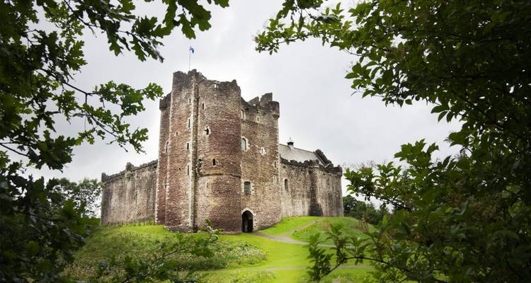 Ancient stone castle surrounded by greenery.