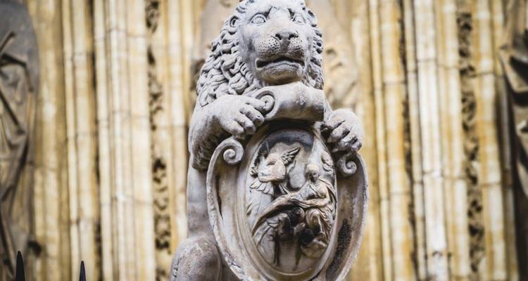 Estatua de león de piedra con un tallado de escudo.