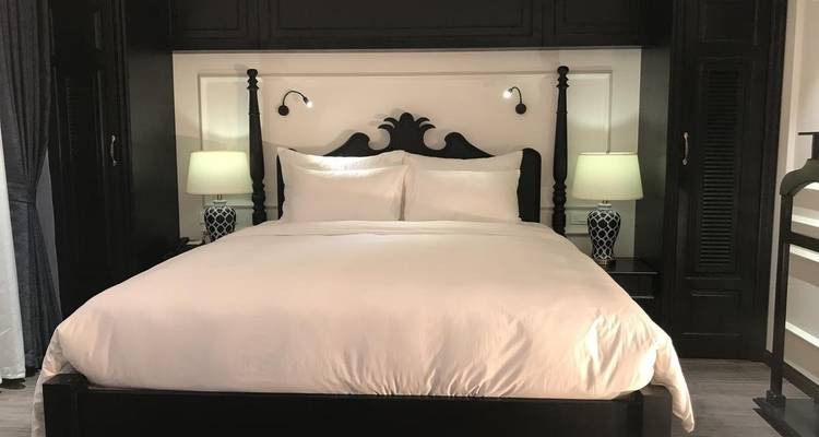 Elegantes Hotelzimmer mit dunklen Holzmöbeln und stimmungsvoller Beleuchtung.