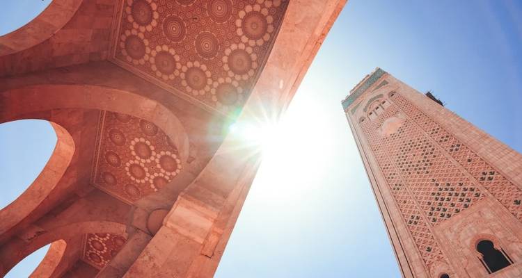 View of Hassan II Mosque tower under a bright sun.
