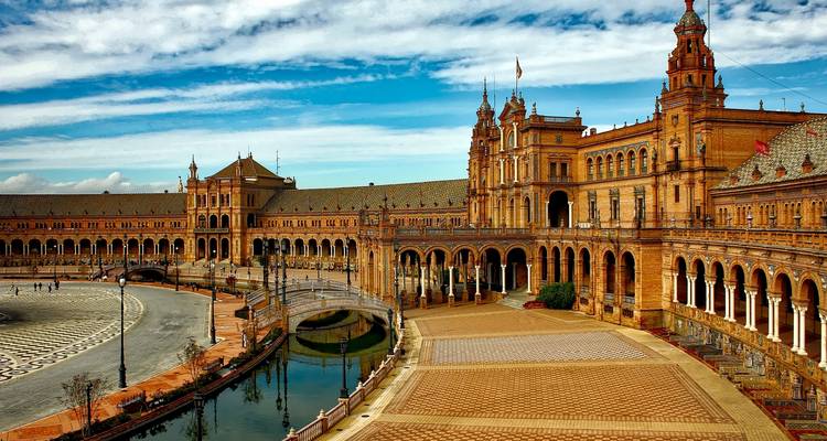 Place d'Espagne à Séville avec une architecture complexe et des voies navigables.