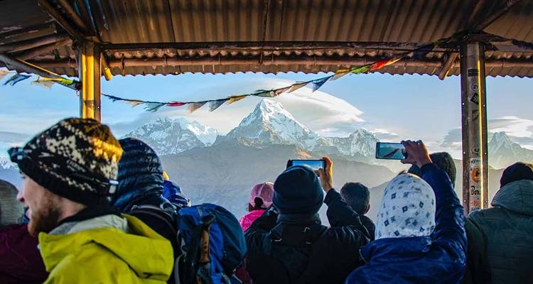 Gente tomando fotos de una cordillera.
