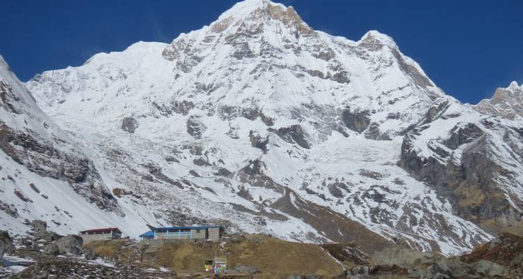 Snow-covered mountain with clear blue sky.
