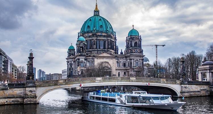 Scenic view of a river with a domed building and a boat.