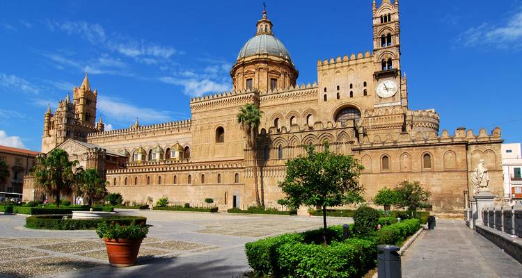 Vue ensoleillée de la Cathédrale de Palerme avec son mélange unique d'architecture normande et arabe entourée de jardins paysagés.