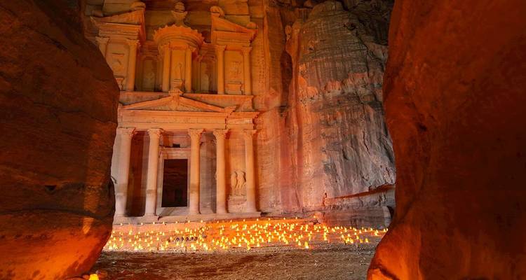 El Tesoro de Petra iluminado por cientos de velas entre imponentes muros de arenisca en la noche