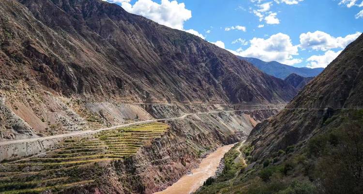 Un canyon profond avec des pentes en terrasses et une rivière boueuse traversant le paysage spectaculaire des Gorges du Saut du Tigre.