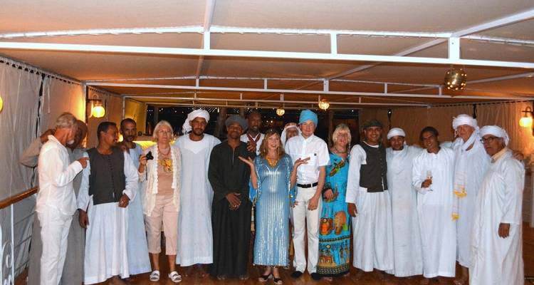 Grupo de personas vestidas con atuendo tradicional en cubierta.