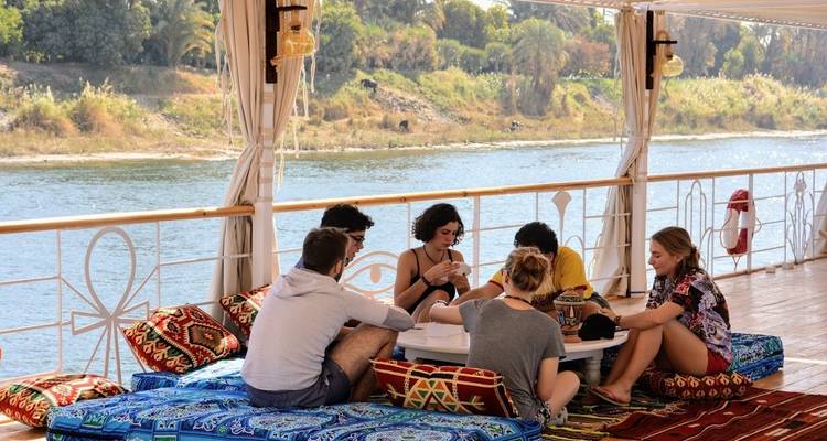 Grupo de amigos jugando un juego en la terraza con vista al río.