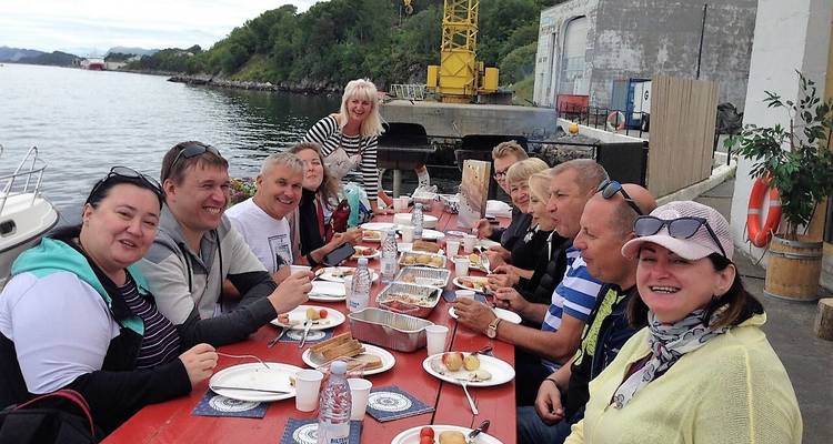 Groupe de personnes profitant d'un repas au bord de l'eau.