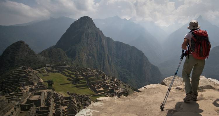 Wandelaar die vanaf bovenaf over Machu Picchu uitkijkt.