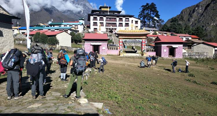 Mensen die naar een klooster in de bergen lopen.