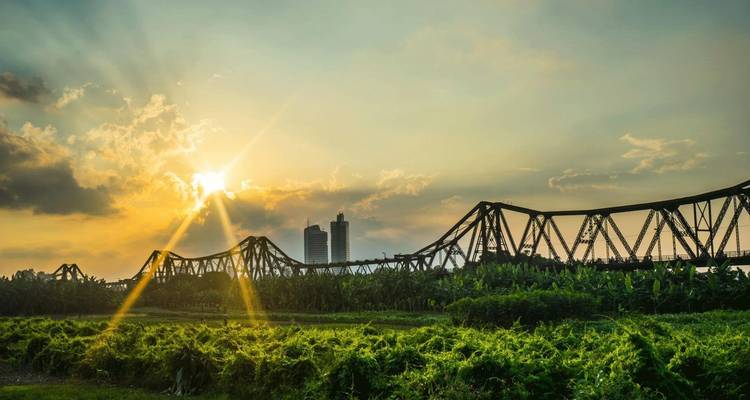 Atardecer sobre un puente y vegetación exuberante