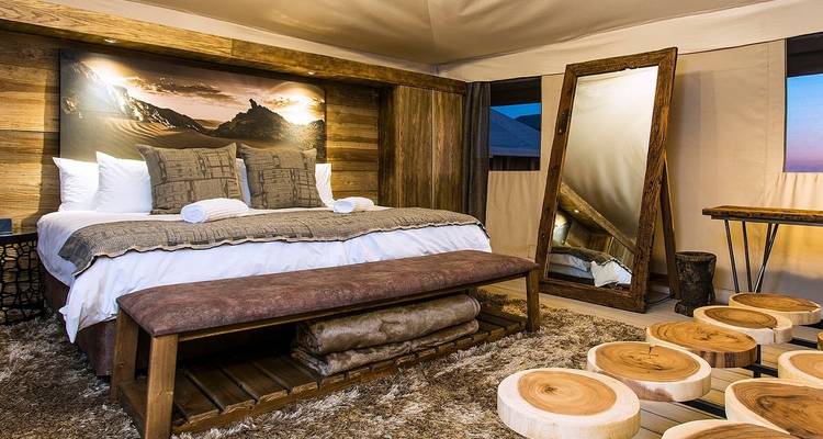 Luxurious wooden cabin bedroom with a large bed and artistic decor.