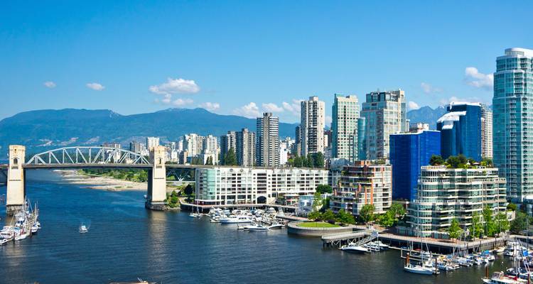 Vista clara del horizonte de Vancouver durante el día con el puente Burrard cruzando False Creek y la marina abajo.