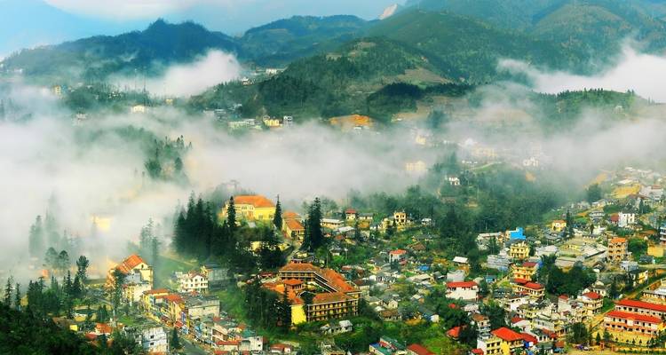 Misty morning view over a town in the mountains with colorful buildings.