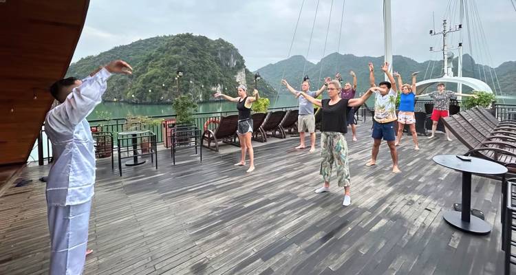Groep mensen die Tai Chi beoefenen op een bootdek.