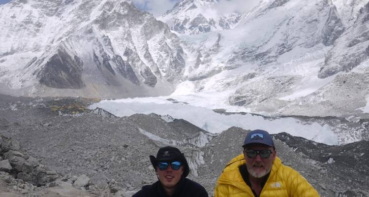 Twee trekkings stellen zich op met de dramatische gletsjer van Everest Base Camp en bergtoppen op de achtergrond