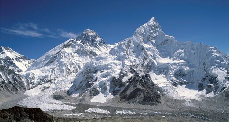Helder uitzicht op imposante, met sneeuw bedekte Himalaya-bergtoppen onder een dieperblauwe hemel