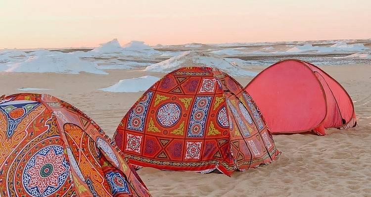 Des tentes colorées installées dans un environnement désertique.