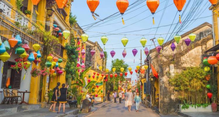 Kleurrijke lantaarns en mensen die langs een oude straat lopen.
