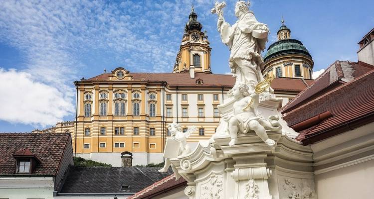 Architecture baroque de l'abbaye de Melk avec des statues au premier plan.