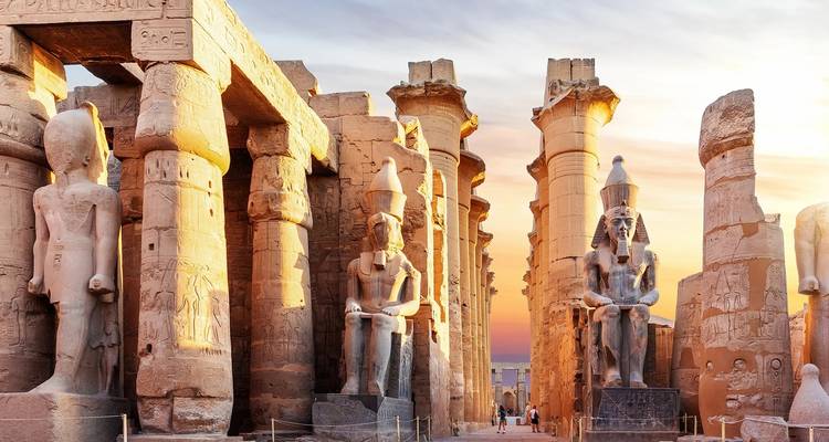 Temple égyptien antique avec de grandes statues et colonnes.