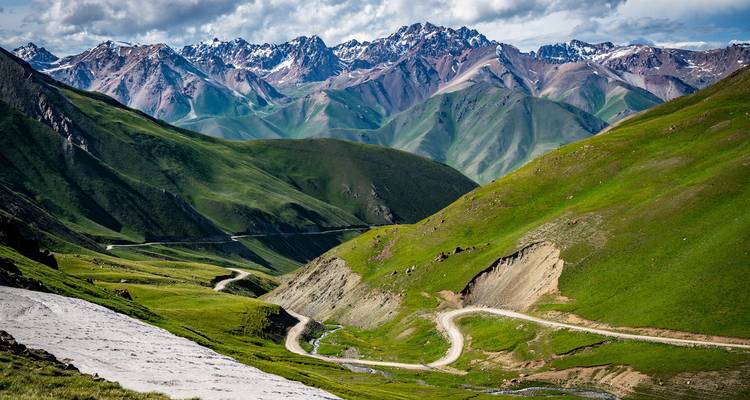 Una vista panorámica de un camino serpenteante a través de montañas verdes.