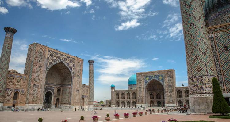 Majestic Plaza del Registan con madrasas ornamentadas de azulejos azules bajo un cielo despejado en Samarcanda, Uzbekistán.