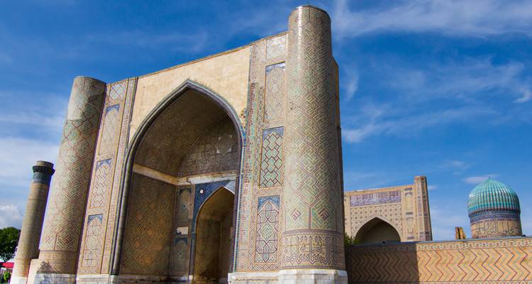 Vista cercana de un gran portal de madrasa con azulejos azules bajo un cielo azul vivido en Samarcanda.