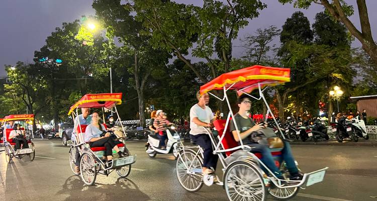Personas montando ciclos en las calles de Hanoi, Vietnam al anochecer.