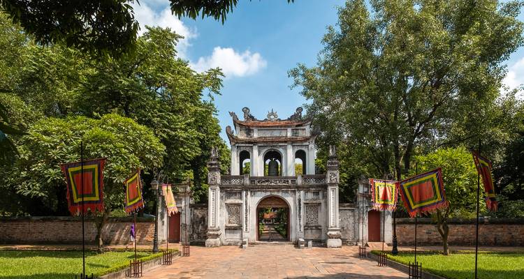 Puerta histórica con arquitectura tradicional en un entorno de jardín.