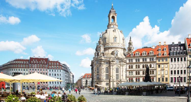 Dresdens barocke Frauenkirche dominiert einen sonnigen Stadtplatz voller Cafés und Besucher.