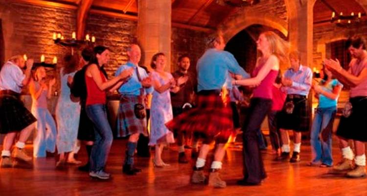 Guests enjoying lively Irish ceilidh in a stone-walled venue