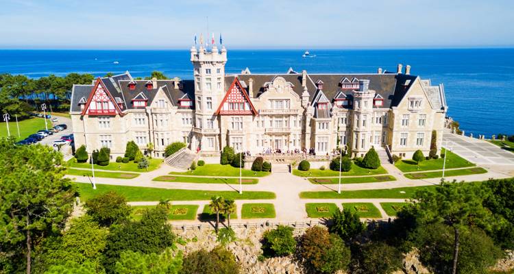 Palacio de la Magdalena alzándose majestuosamente sobre un promontorio verde por encima del mar azul