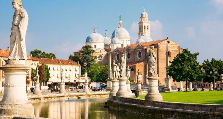 Basilika Santa Giustina und Statuen, die sich im Kanal des Prato della Valle von Padua an einem sonnigen Morgen spiegeln.