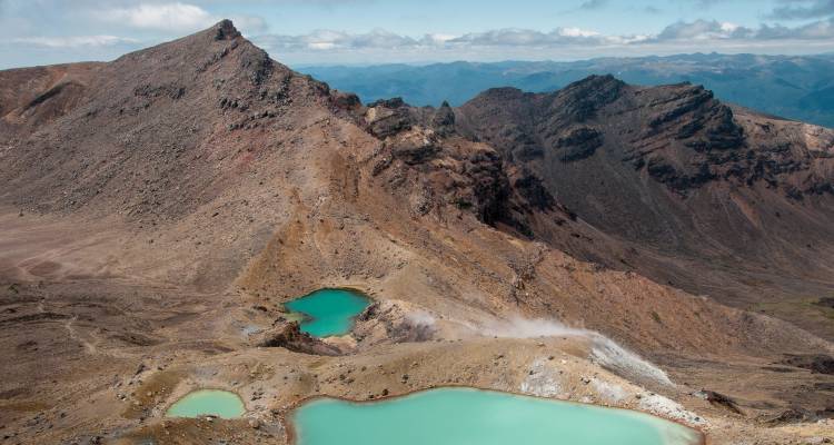 Vue panoramique d'une région volcanique avec des lacs turquoise.