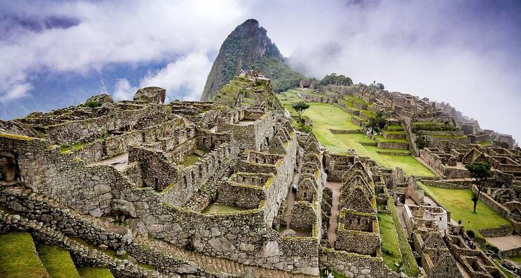 Ruines du Machu Picchu avec une montagne couverte de brume.