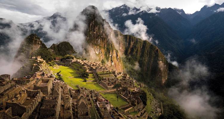 Les ruines anciennes du Machu Picchu avec des montagnes brumeuses en arrière-plan.