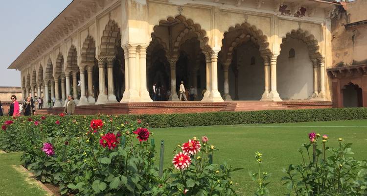 Exterieur van een historisch gebouw met bogen en tuin.